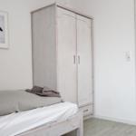 Schlafzimmer mit Bett, Kleiderschrank und Wandbild