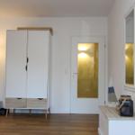 Helle Eingangshalle mit Kleiderschrank, Tür und Wandregalen.