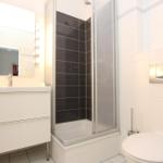 Badezimmer mit Dusche, Waschbecken und Toilette.