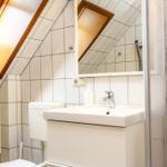 Badezimmer mit Dachschrägen, Waschbecken, Spiegel und Dusche