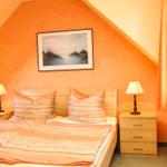 Schlafzimmer mit Dachschrägen, Bett, Nachttischen und Bild an der Wand.