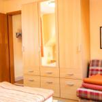 Schlafzimmer mit Bett, Kleiderschrank und Sitzbank mit Decke.
