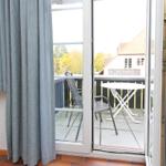 Durch die Glastür ist eine Terrasse mit Tisch und Stühlen sichtbar.