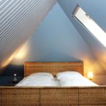 Schlafzimmer mit Dachschrägen, Dachfenster und Rattanbett