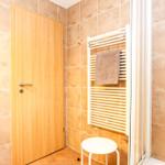 Badezimmer mit Holztür, Handtuchhalter und Heizkörper.