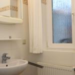 Bad mit Waschbecken, Spiegel und Fenster mit Glastüren