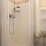 Badezimmer mit Dusche, Waschbecken und Spiegelschrank