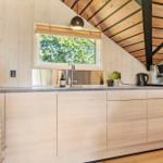 Küche mit Holzwand, Fenster und Küchenspüle.