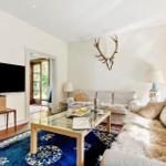 Wohnzimmer mit Sofa, Glas-Tisch und Wanddekoration
