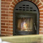Ein Kaminofen mit brennendem Feuer in einem roten Ziegelofen.
