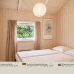 Schlafzimmer mit Holzwand, Fenster, Bett und Decke.