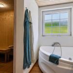 Bad mit Whirlpool und Sauna im Hintergrund.