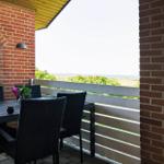 Terrasse mit Tisch und Stühlen, Blick auf Landschaft und Meer.