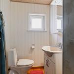 Badezimmer mit Toilette, Waschbecken und Dusche mit Glaswand.