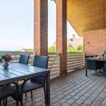 Terrasse mit Tisch, Stühlen, Grill und Blick auf die Landschaft.