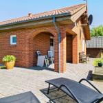Rotes Backsteingebäude mit Terrasse und Liegestühlen im Garten.