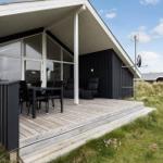 Haus mit Terrasse, Tisch und Stühlen, Sitzgelegenheiten und Satellitenschüssel.