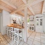 Küche mit Holzdecke, Sitzgelegenheit und Blick auf den Garten.