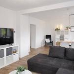 Wohn- und Essbereich mit Sofa, Fernseher und Esstisch.