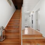 Haus mit Holztreppe und Flur. An der Treppe hängt eine Laterne.