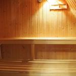 Sauna mit Holzwand, Sitzbank und Eimer