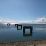 Meer mit Ruinen im Hintergrund, Strand im Vordergrund