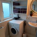 Waschmaschine, Spülung und Handtuchregal im Badezimmer