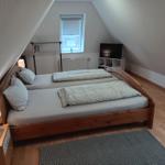 Schlafzimmer mit Doppelbett, Fernseher und Fenster