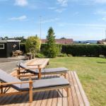 Terrasse mit Liegestühlen und Blick auf den Garten und die Ferne.