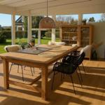 Esszimmer mit Holztisch, schwarzen Stühlen und Blick auf Garten.