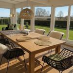 Esszimmer mit Holztisch, Stühlen und großem Fensterblick auf Garten