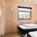 Zimmer mit Holzwand, Fenster, Bett und Schreibtisch