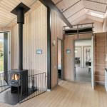 Holzhaus mit Kamin, Schlafgelegenheit oben und Blick auf den Garten.