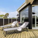 Terrasse mit zwei Liegen, Tisch und Blick auf die Umgebung.