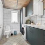 Badezimmer mit Toilette, Waschmaschine und Waschbecken unter grauen Schränken.