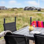 Terrasse mit Tisch und Stühlen, Blick auf Grasland und Häuser im Hintergrund.