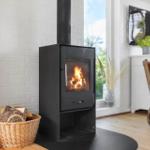 Kaminofen mit brennendem Holz, Korb mit Brennholz, Fernseher und Sessel im Wohnzimmer.