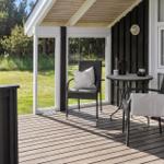 Terrasse mit Tisch, zwei Stühlen und Grill. Blick auf grünen Garten.
