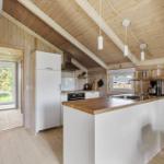 Küche mit Holzdecke, weißer Arbeitsfläche und Kücheninsel.