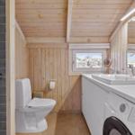 Badezimmer mit Toilette, Waschmaschine und Fenster mit Blick nach draußen.