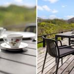 Tisch mit Tassen auf Terrasse mit Blick auf Grünflächen