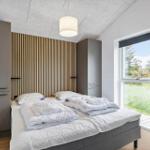 Schlafzimmer mit Bett, Kleiderschränken und Fenster zum Garten.