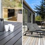 Terrasse mit Liegestühlen und Tisch. Blick auf Haus und Bäume.