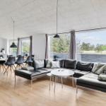 Wohn- und Essbereich mit großem Sofa, Esstisch und Fenster zur Außenterrasse.