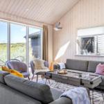 Wohnzimmer mit Sofa, Sesseln und großem Fenster zur Aussicht.