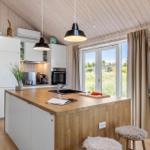 Küche mit Holzoberfläche, Fenster und weißen Schränken