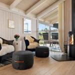 Zwei schwarze Sessel mit Felldecken, Kamin und Terrassentür im Wohnzimmer.