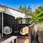 Terrasse mit zwei Stühlen, Pflanzen und dänischer Flagge im Hintergrund.