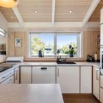 Küche mit Holzdecke, Fenster und modernen Geräten