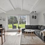 Wohnbereich mit Sofa, Tisch und Blick auf den Garten.